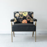 Elegant accent chair with a luminous gold metal frame, plush leather seat, and velvet floral backrest, perfect for sophisticated interiors.